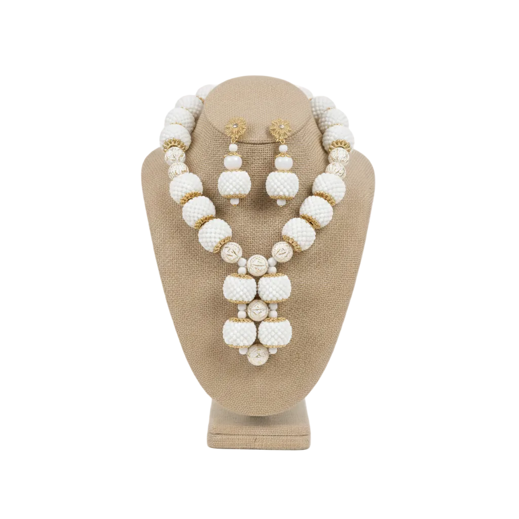 White beaded necklace and earrings set on a beige mannequin bust against a white background